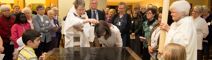 Denise, sponsors and the Sunday Assembly community gather at the baptismal font for Denise's baptism (photo by Sandy Wojtal-Weber)